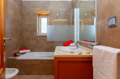 a bathroom with a tub and a sink and a toilet at Villa Florida by Algarve Vacation in Albufeira