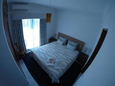 a bedroom with a large bed with a window at Casa de Vilamoura in Vilamoura