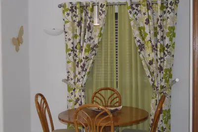 a table and chairs in a room with a curtain at Casa de Vilamoura in Vilamoura