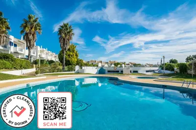 a large swimming pool with palm trees in the background at 3 bedroom apartment in Oura Albufeira with amazing pool at walking distance to beach, strip and old town, WIFI and AC, private condo in Albufeira