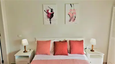 a bedroom with a bed with pink pillows and two lamps at 3 bedroom apartment in Oura Albufeira with amazing pool at walking distance to beach, strip and old town, WIFI and AC, private condo in Albufeira
