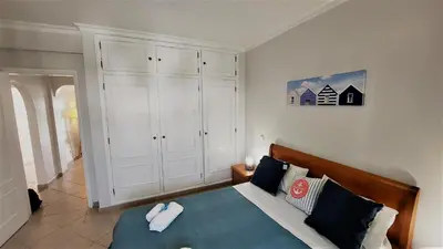 a bedroom with a bed and a white cabinet at 3 bedroom apartment in Oura Albufeira with amazing pool at walking distance to beach, strip and old town, WIFI and AC, private condo in Albufeira