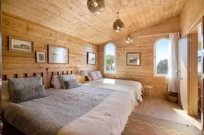 a bedroom with a large bed and two windows at Cabana Gardenhouse in Loulé