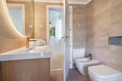 a bathroom with a sink and a toilet and a mirror at Apartment Dansk in Almancil