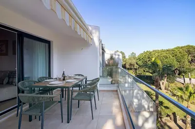 a balcony with a dining table and chairs on a balcony at Apartment Dansk in Almancil