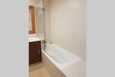 a white bathroom with a tub and a sink at Aparto Golf in Guia