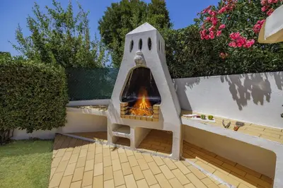 a outdoor oven with a fire in it on a patio at Villa Aldeia by Villa Plus in Albufeira