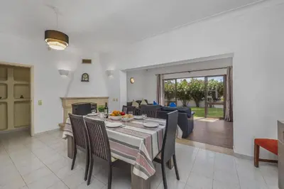a dining room and living room with a table and chairs at Villa Aldeia by Villa Plus in Albufeira