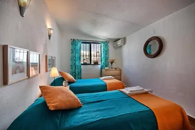 two beds in a room with blue and orange at Villa Altis by Villa Plus in Albufeira