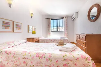 a bedroom with two beds and a dresser and a mirror at Villa Altis by Villa Plus in Albufeira