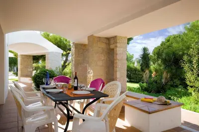 an outdoor dining area with a table and white chairs at Villa Elo by Villa Plus in Albufeira
