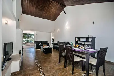 a dining room and living room with a table and chairs at Villa Elo by Villa Plus in Albufeira