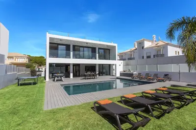 a house with a swimming pool and some chairs at Villa Eve by Villa Plus in Olhos de Água
