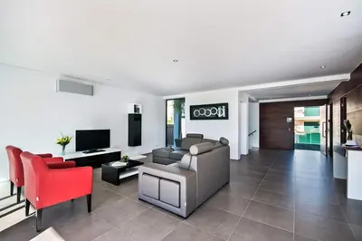 a living room with a couch and red chairs at Villa Eve by Villa Plus in Olhos de Água