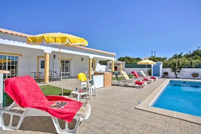 a villa with a swimming pool with chairs and an umbrella at Villa Miguel by Villa Plus in Galé