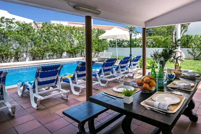 a patio with a table and chairs and a pool at Villa Montechoro by Villa Plus in Albufeira