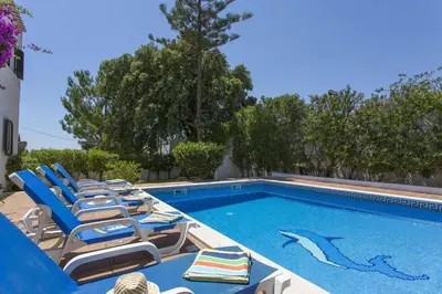 a swimming pool with lounge chairs and a swimming pool at Villa Montechoro by Villa Plus in Albufeira