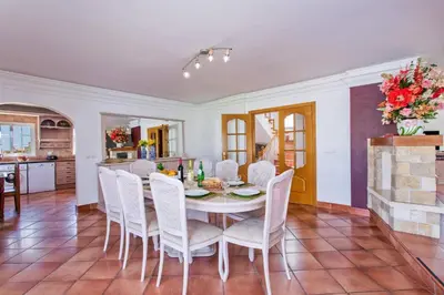 a kitchen and dining room with a table and chairs at Villa Soni by Villa Plus in Olhos de Água