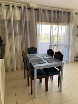 a dining room table with chairs and a window at House Amendoeiras , Vila moura in Vilamoura
