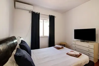 a bedroom with a bed and a flat screen tv at Villa Isabel in Loulé