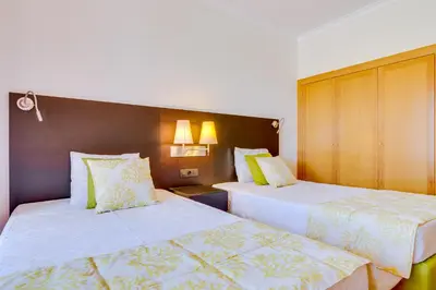 a hotel room with two beds with white sheets at AL - Apartamento Vila Sol F5 AA in Vilamoura