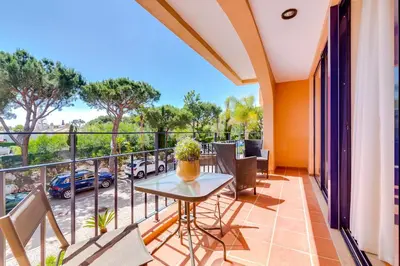 a balcony with a table and chairs and a view of a parking lot at AL - Apartamento Vila Sol F5 AA in Vilamoura