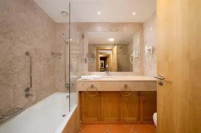 a bathroom with a tub and a sink and a shower at AL - Apartamento Vila Sol F5 AA in Vilamoura