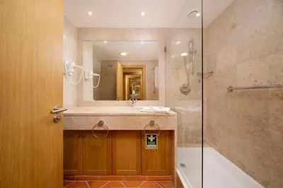 a bathroom with a sink and a shower and a mirror at AL - Apartamento Vila Sol F5 AA in Vilamoura