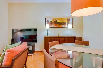 a dining room and living room with a table and chairs at AL - Apartamento Vila Sol F5 AA in Vilamoura