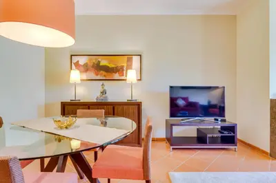 a dining room with a glass table and a tv at AL - Apartamento Vila Sol F5 AD in Vilamoura