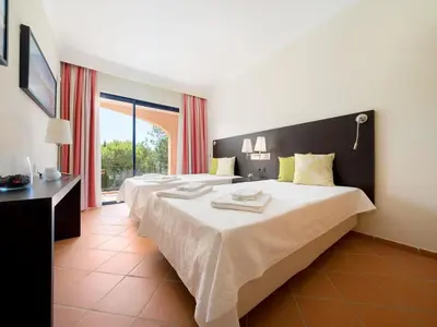 a hotel room with two beds and a window at AL - Apartamento Vila Sol F5 AD in Vilamoura