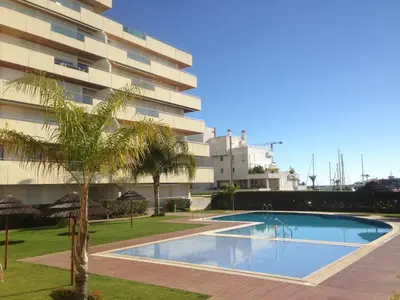 a large umbrella sitting next to a swimming pool at Divine Vilamoura Aquamar 106 by JG Apartments in Vilamoura