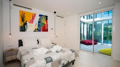 a bedroom with a bed and a painting on the wall at Central Vilamoura Townhouse in Quarteira