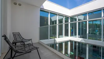 a balcony with two chairs and glass windows at Central Vilamoura Townhouse in Quarteira