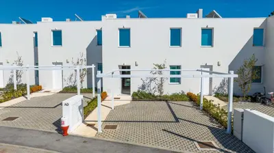 a white building with a basketball court in front of it at Central Vilamoura Townhouse in Quarteira