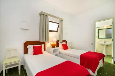 two beds in a white room with red sheets at WHome | Balaia 3-Bed Family Holiday Villa in Olhos de Água