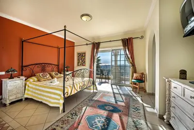a bedroom with a canopy bed and a balcony at Villa Nenufa by Villa Plus in Albufeira