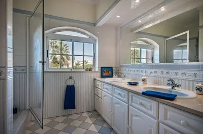 a bathroom with two sinks and a shower at Villa Nenufa by Villa Plus in Albufeira