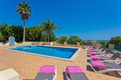 a row of lounge chairs next to a swimming pool at Villa Nenufa by Villa Plus in Albufeira