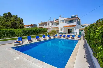 a swimming pool with lounge chairs and a house at Villa Animado by Villa Plus in Albufeira