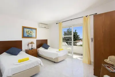 a bedroom with two beds and a balcony at Villa Animado by Villa Plus in Albufeira