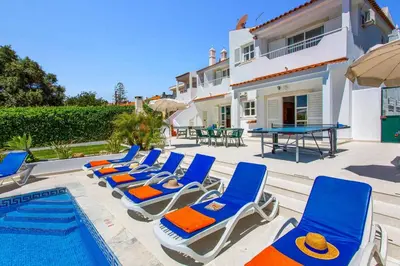 a bedroom with two beds and a table and chairs at Villa Animado by Villa Plus in Albufeira