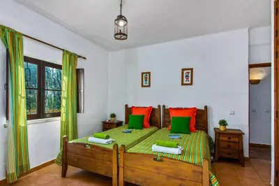 a bedroom with a bed with green and orange pillows at Villa Casa do Laguinho by Villa Plus in Albufeira