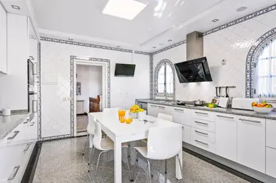 a white kitchen with a white table and chairs at Villa Aldeia Cristina by Villa Plus in Albufeira