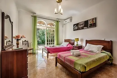 a bedroom with two beds and a window at Villa Cabrita, Superb location, large villa, walk to restaurants, supermarkets beach in Guia