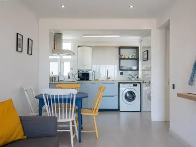 a kitchen with a blue table and chairs in a room at Cosy beach apartment in Albufeira centre in Albufeira