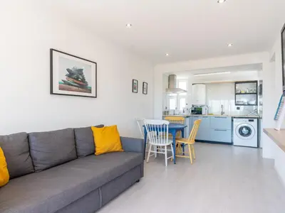a living room with a couch and a table and chairs at Cosy beach apartment in Albufeira centre in Albufeira