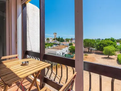 a balcony with a wooden table and a view at Cosy beach apartment in Albufeira centre in Albufeira
