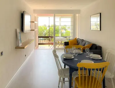 a living room with a table with chairs and a couch at Cosy beach apartment in Albufeira centre in Albufeira