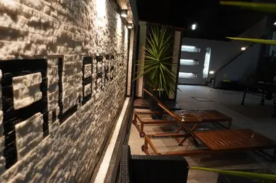 a brick wall with two tables and a plant at AL Barbinha in Faro